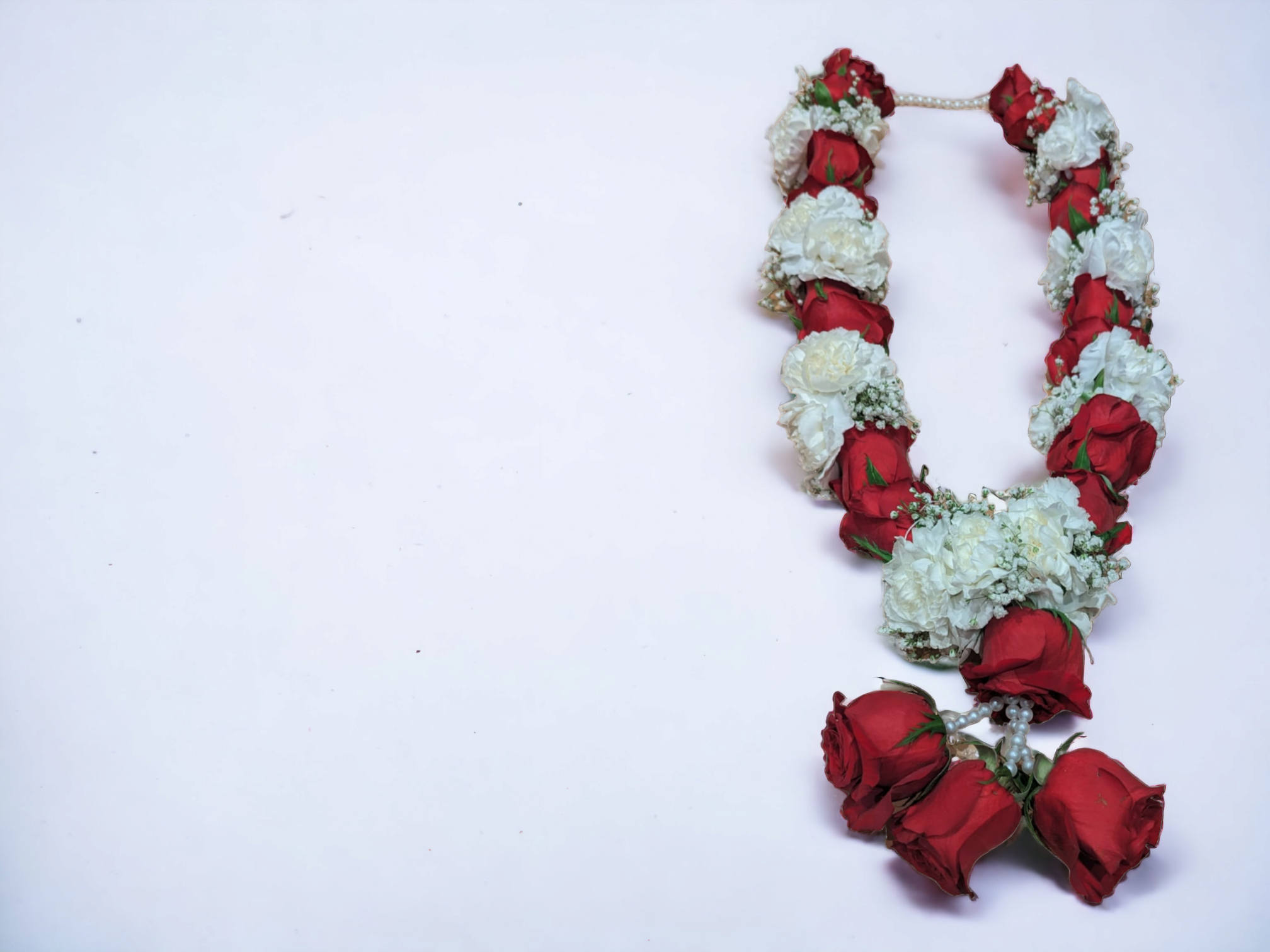 Beautifully arranged rose and jasmine malai, featuring vibrant rose petals and fragrant jasmine blooms, commonly used for decorations and rituals.